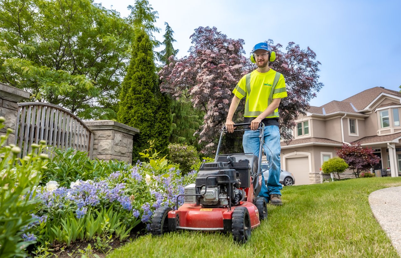 A crew member mowing the lawn