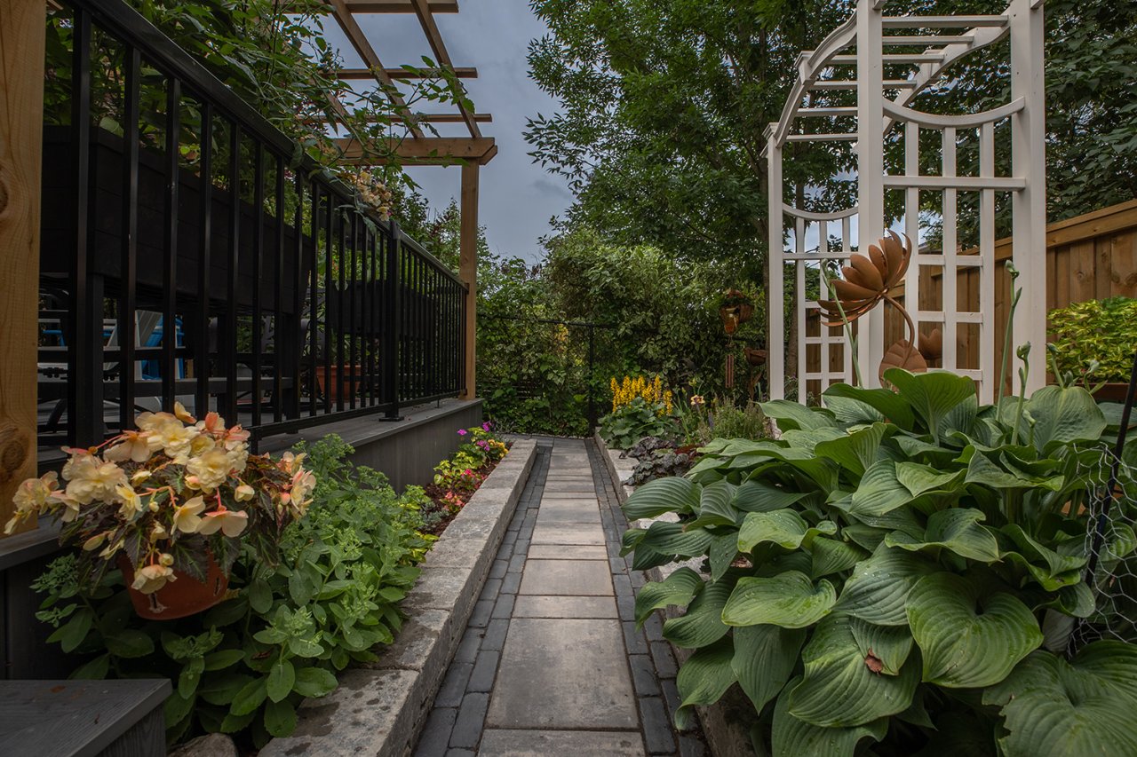 Residential landscape backyard with stone pathway and garden